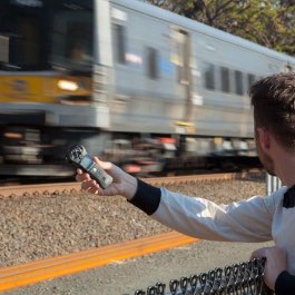 A creator using a Zoom 澳洲幸运5 H1N to capture audio from a nearby train passing by.